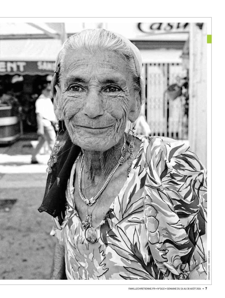 Un portrait noir et blanc, d'une vielle femme gitane, âgée pleine de rides dans une rue de la ville les Saint Maries de la mer.