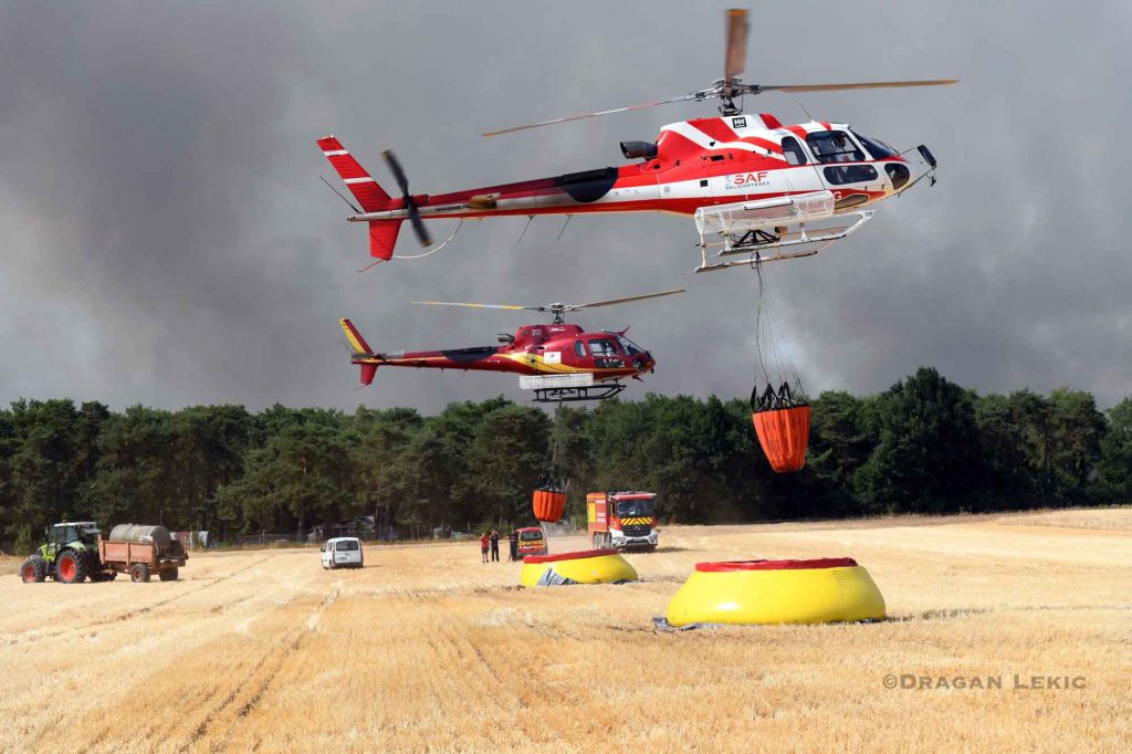 Close view of two firefighting helicopters collecting water from a portable reservoir during operations against the major wildfire in the Forest of Fontainebleau near Fontainebleau in Ile de France France on July 13, 2026. The aircraft are engaged in aerial firefighting missions to slow the spread of the exceptional forest fire south of Paris.///
Vue rapprochee de deux helicopteres bombardiers deau remplissant leurs reservoirs dans une citerne souple mobile lors des operations contre le vaste incendie de la foret de Fontainebleau pres de Fontainebleau en Ile de France France le 13 Juillet 2026. Les appareils participent aux missions aeriennes de lutte contre l incendie afin de limiter la propagation de ce feu de foret exceptionnel au sud de Paris.